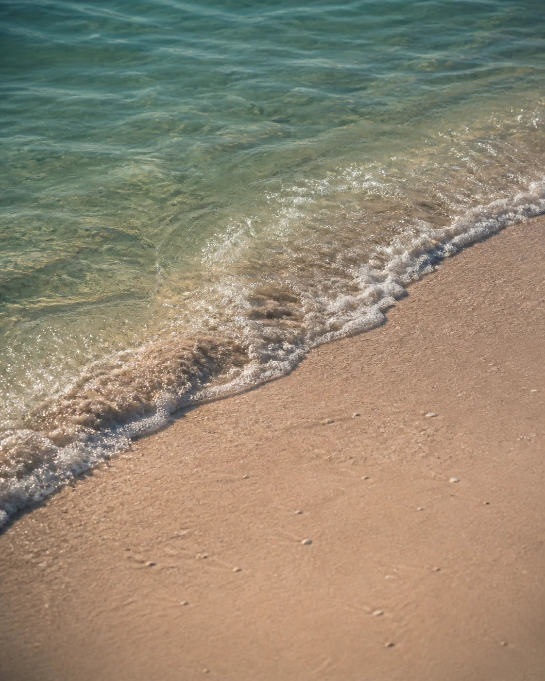 Clear Caribbean water moving over pale sand